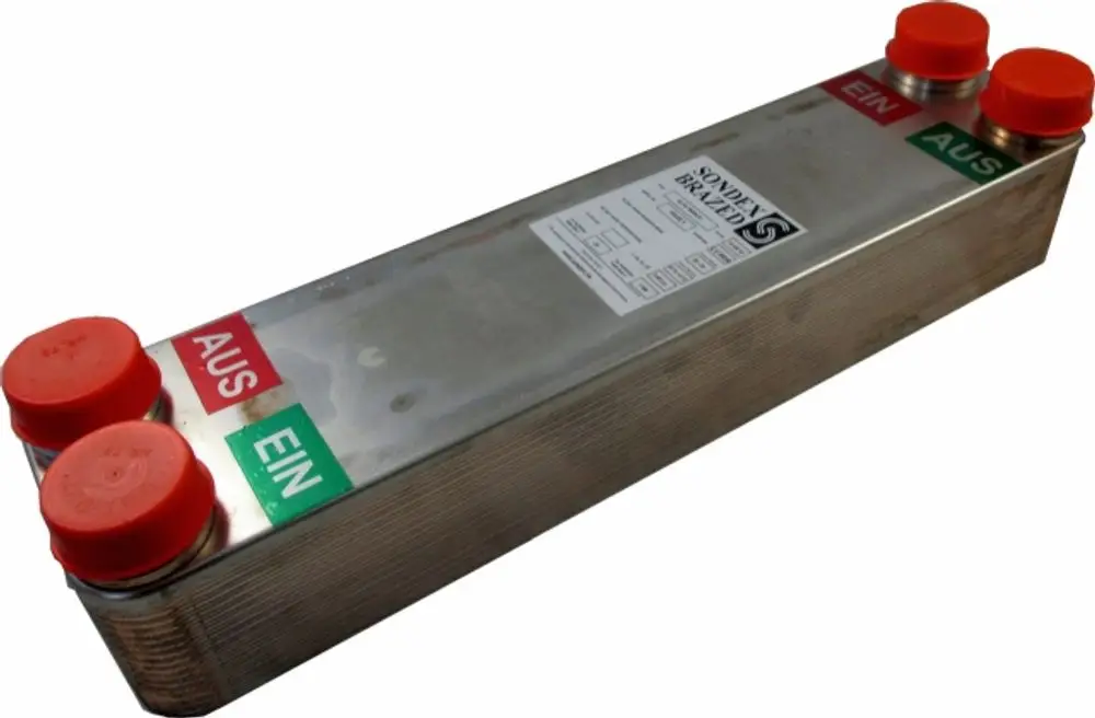 Plattenwärmetauscher mit metallischer Oberfläche und roten Anschlusskappen. Auf dem Gehäuse sind Beschriftungen für Ein- und Ausgang sichtbar. Hersteller ist Wolf.